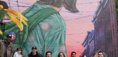 Le groupe des participant.es et les artistes devant la nouvelle murale